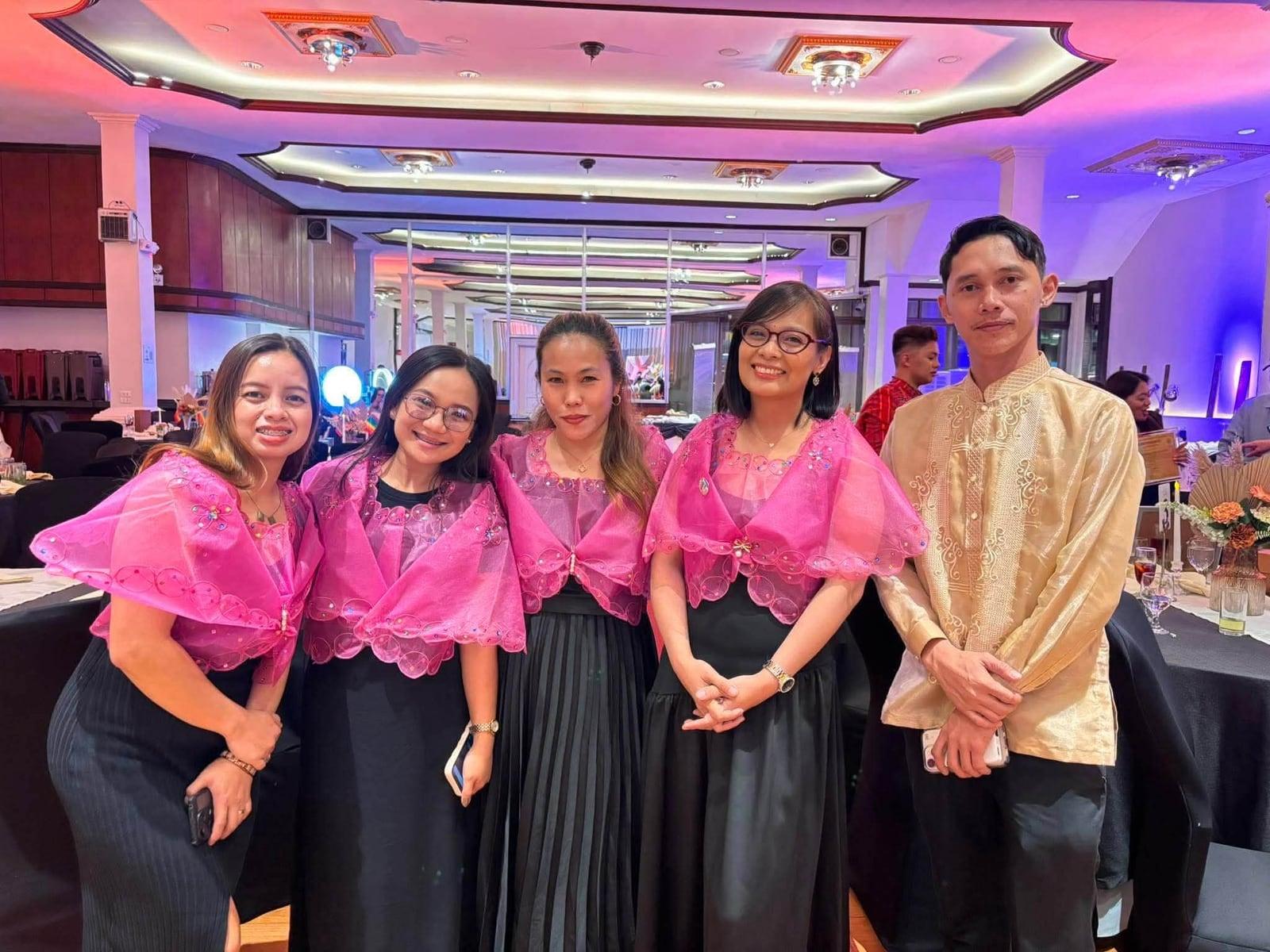 The team in formal pink barong and black, standing together at a corporate event
